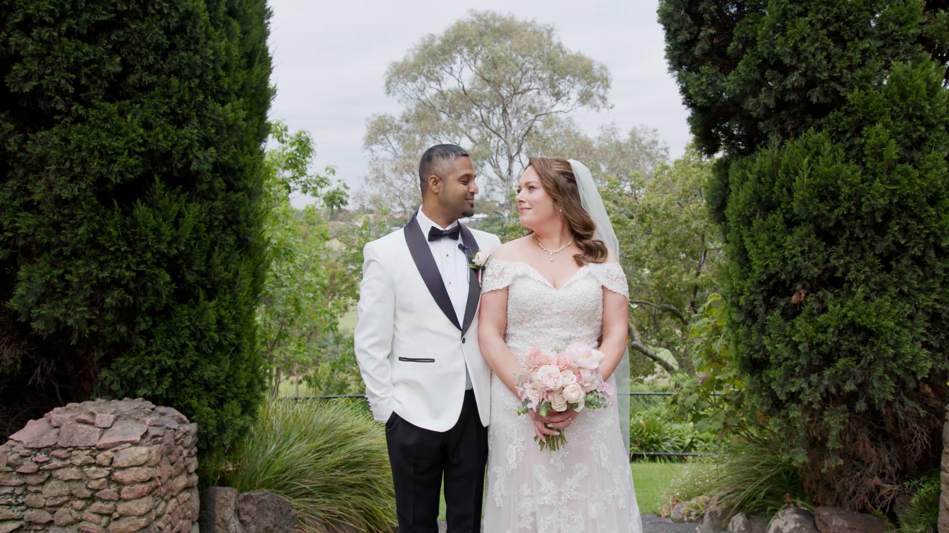 Nathan and Ally standing together in a garden on their wedding day
