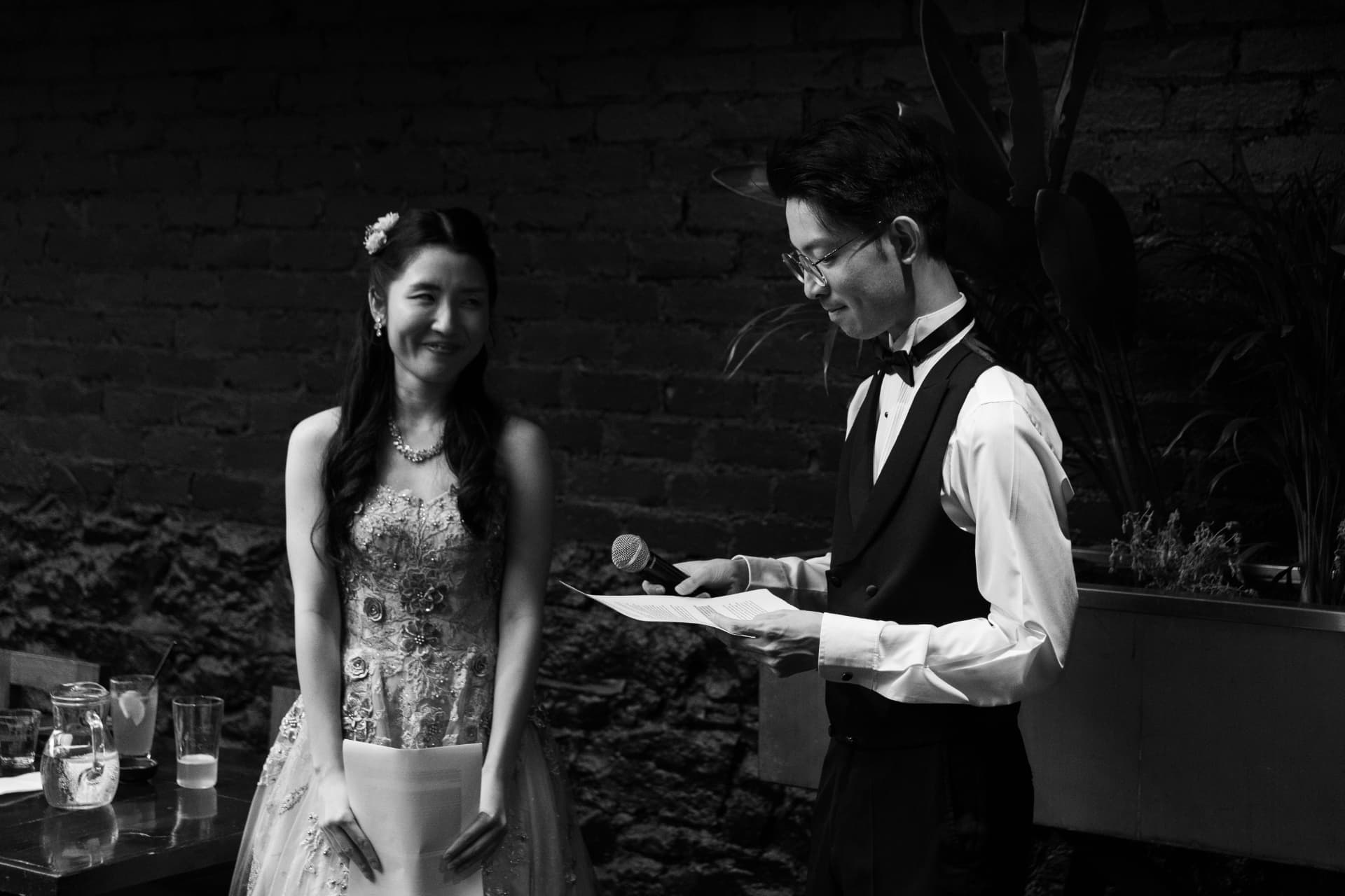 Alex reading a speech to Aya at their wedding reception